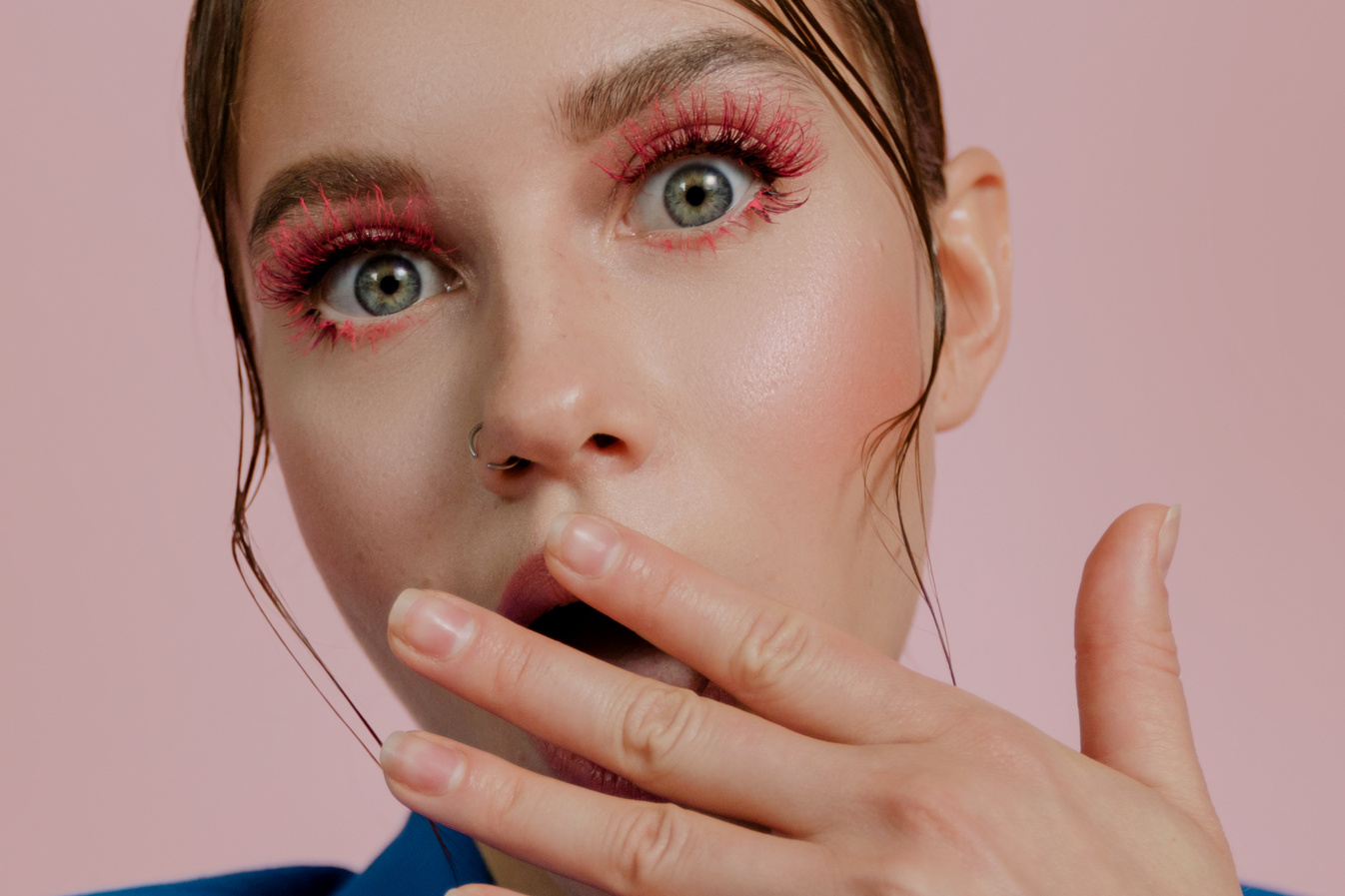 A Shocked Woman with Pink Lashes Looking at the Camera